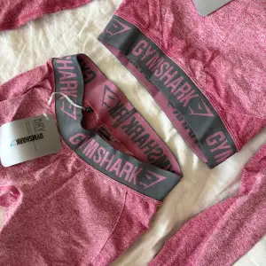 Croppad träningstopp och byxor i rosa från Gymshark. Storlek XS på båda delarna. Normala i storleken.  Aldrig använd, med prislappar kvar. 400kr för båda två. Säljer även i gråfärg.