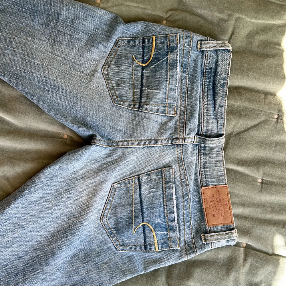 säljer dessa as snygga lågmidjade american eagle jeans! jag har sytt på kanterna men det ger en extra detalj, måttet tvärs över ca 39/40 cm💋🩷helt nya inte använda bara provat på, inga defekter💝🩵. Jeans & Byxor.
