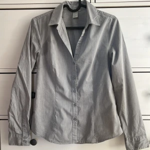 Figursydd skjorta - Figursydd skjorta i perfekt skick i storlek 36, från H&M. Köparen står för frakt, (BVSA), finns katt i hemmet!