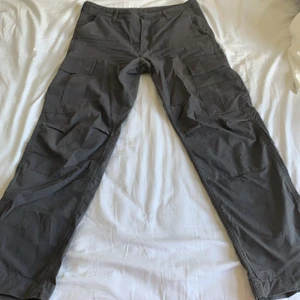 Carhartt byxor - Säljer mina gråa vida carhartt cargobyxor i storlek 31x32 som tyvärr inte kommer till användning längre