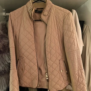 Zara jacka - En beige höst jacka med bruna guld detaljer från zara, sitter jätte fint på... jackan är helt ny storlek 34 inga defekter har bara legat i garderoben. 