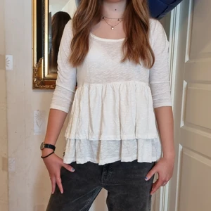 Vit tröja - En superfin vit tröja med volanger på! Storleken är L men sitter som en S eftersom att jag själv har storlek S