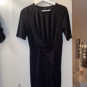 The perfect black mini - Världens skönaste klänning behöver nytt hem! Så otroligt skönt material och är inte urringad alls, som en vanlig t-shirt. Klänningen har en omlott-detalj vid magen som ger en fin detalj! Aldrig använd så är i nyskick 💗🌷☀️