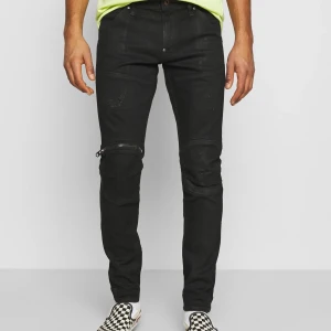 G-STAR RAW 5620 3D ZIP KNEE | Skinny - Orinialpris: 1050kr. Knappt använda, mycket stretchiga jeans med mörka metallnitar som detaljer. Jeansmaterialet är bekvämt och mjukt och byxorna har inga skador. Högra fickan har en liter innerficka och dragkjedjan på knät går att öppna som en ficka. Bakfickorna är rymliga och slutet av byxorna har en extra tygbit som går att vika upp på ett snyggt sätt för att justera längden. 