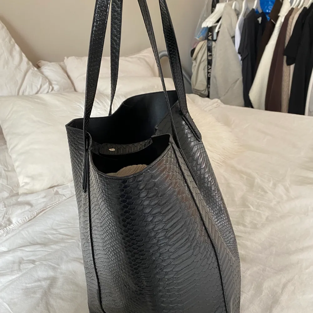 Stor svart väska från NELLY   Läderimitation  Kan förslutas med knapp på insidan  Mått: Bredd 37,5 cm, Höjd 34 cm, Djup 20 cm . Väskor.