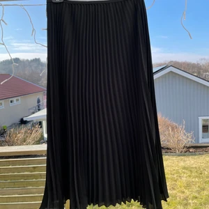 Veckad långkjol  - Veckad långkjol säljes. Snyggt band upptill. Aldrig använd. Säljes pga flytt.