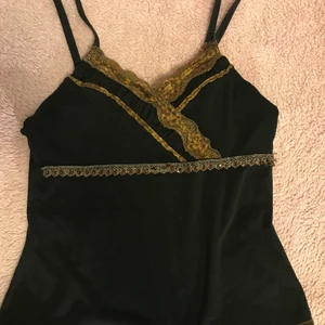 svart spets top - svart trendigt linne med bruna spetsdetaljer och guldband under bysten🤎🖤 materialet är genomskinligt nertill, inte upptill - så man kan ha på den utan något under. reglerbara axelband. 