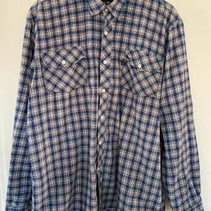 Blå-beige-rutig skjorta, strl XXL - Blå-beige-rutig skjorta Blåkläder workwear Strl XXL  Bra skick. En fläck, se foto.  Djur- och rökfritt hem.