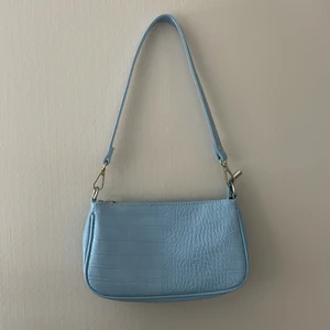 Baguette bag, Gina tricot  - En ljusblå/ pastellblå baugette bag från Gina tricot. Väskan är använd ca 2-3 gånger, alltså som ny. Har för många väskor därför säljer jag den, men den är så fin att ha både under vinter och sommar! Köparen står för frakt och returneras ej💙
