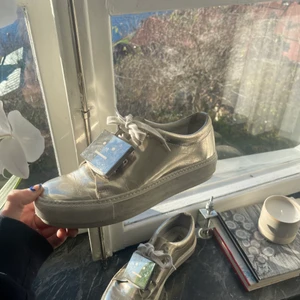 Acne skor  - Ett par silvriga sneakers från acne studios i storlek 39