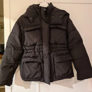 Gina Tricot Alba Puffer 34 - Säljer en pufferjacka från Gina Tricot i storlek 34. Vindslå och tryckknappar. Sparsamt använd, som ny. Fyra fickor fram och en snodd i midjan som går att dra åt. Varm och rymlig. Passar bra på mig som har xs-s. Kan skickas spårbart med posten för 66 kr.