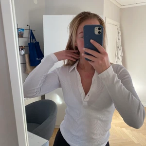 Vit ribbad tröja från ginatricot  - Säljer denna fina, vita tennisliknande tröja som är ribbad och har en krage med knapar framtill. Den kommer tyvärr inte till användning längre. Storleken är XS. Frakt tillkommer om inget annat är överenskommet 😊