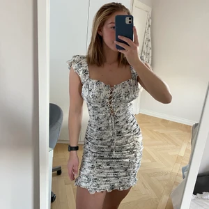 Sommarklänning från prettylittlething - Säljer denna jättesnygga sommarklänning i silke med blåa blommor på. Den är använd Max en handfull gånger, så den är i väldigt gott skick. Storleken är 36 men skulle säga att det är 34/36.  Frakt tillkommer om inget annat är överenskommet ☺️