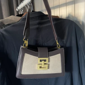 Axelremsväska  - Jättefin väska i brun/beige fakeläder🤎 både dragkedja och spänne. Säljer pågrund av att jag inte får nån använd av den tyvärr🤎 köparen står för frakten 