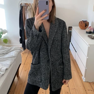 Oversize blazer-jakke i grå/sort mønster - Jakke med virkelig god pasform, hvis man gerne vil have et oversized look. Den er fra Mango, med én knap foran og dybe lommer.