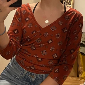 Röd tröja - En röd tröja med mönster som är v-ringad, stretchig och aldrig använd 🥰