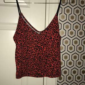 Säljer denna röda topp i leopard mönster från BikBok! Storlek XS! Aldrig använd! I fint skick!