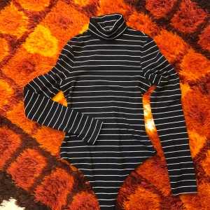 Randig Body - Svart- och vitrandig långärmad body med polokrage. Något nopprig men annars väldigt fint skick. Storlek 36. Går att mötas upp i Hagfors eller skickas med posten där köparen står för frakten. 