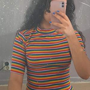 En regnbåges tröja som är tajt och fin 