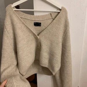 Beige stickad tröja - En supermjuk och fin stickad tröja med knappar ifrån Asos. Kommer aldrig till användning tyvärr. Lite kortare modell med långa armar. Storlek 36