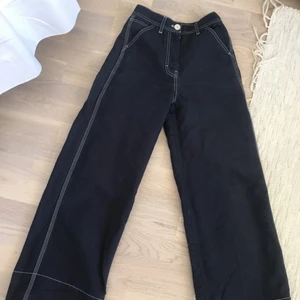 Byxor ARKET storlek 34 - Marinblå byxor med vit söm från ARKET. Fin passform och raka vida ben. Storlek 34. Fint skick. Säljer endast för att jag gått upp i storlek.. älskar dom.