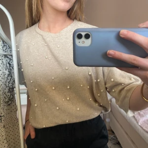 T-shirt med pärlor  - En beige mjuk T-shirt med längre armar och vita pärlor på, frakt tillkommer, pris kan alltid diskuteras 