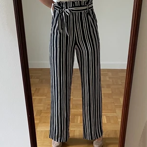 Oanvända höga byxor, knyt i midjan, stlk S - Säljer mina helt oanvända höga blå/vit-randiga byxor med knyt i midjan. Prislapp sitter kvar, nypris 349kr, från H&M. Mjukt strykfritt material som faller snyggt och sitter smickrande över rumpa/höfter. 