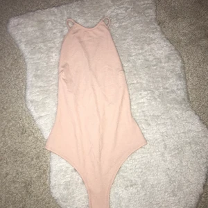 Body med öppenrygg - Rosa body från Nelly med öppen rygg. Aldrig använd! 