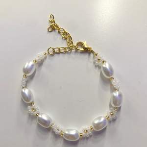 Ett superfint armband med fina vita pärlor och blommor gjorda av glaspärlor. Armbandet är 17 cm + förlängningskedja.☺️ Frakten ingår i priset. ❤️