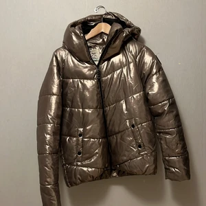 Metallic vinterjacka strl 170 - Metallic vadderad vinterjacka från H&M. Strl 170. Sparsamt använd i super bra skick. Varm och skön. 