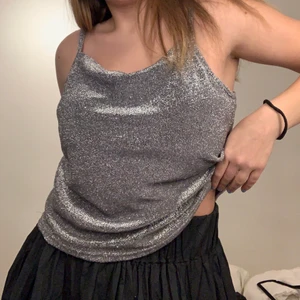 Silver Topp - Säljer mitt skitsnygga linne i en glittrig silver färg. Den är i storlek 44 men skulle säga att den passar som M ungefär. Endast använd 1 gång. Perfekt till fester, nyår, jul osv✨🥰🌟!! Frakt 45kr.