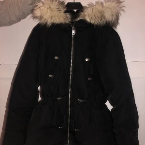 Vinterjacka - Vinterjacka i storlek 42, i bra skick och använd få gånger. Fakepäls luva, resår i midjan