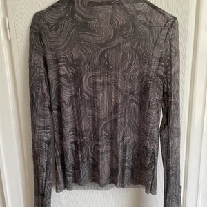 Genomskinlig topp med mönster - En grå beige fest topp, rak i halsen. Lagom genomskinlig tröja från & other stories. Mjukt material, och inte så sträv som många andra liknande tröjor är.