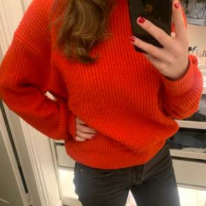 Knappt använd stickad tröja i en fin orange/röd färg, passar S-XL