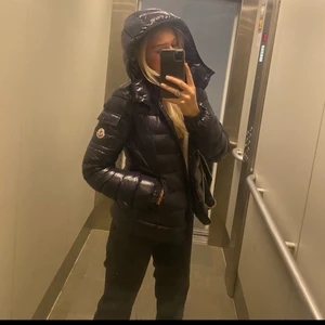 Moncler jacka  - Säljer min alldeles nya marinblåa Moncler jacka som bara är använd denna vinter, finns ett pyttelitet hål som knappt syns men därav priset! Äktebevis finns. Barnstorlek 14 men passar som en S. Luvan är avtagbar. Skriv för fler bilder💓💓