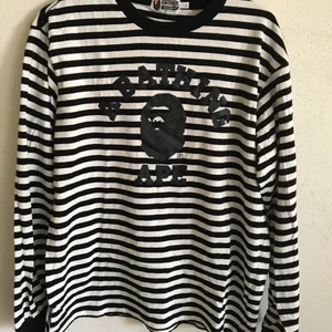 Unisex Bape Striped Long Sleeve Tee - Unisex Bape / A Bathing Ape Striped Long Sleeve T-Shirt  Size large, fits like a regular men’s medium. Great condition, no flaws or damage.  DM if you need exact size measurements.   Buyer pays for all shipping costs. All items sent with tracking number.   No swaps, no trades, no offers. 