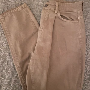 Beige jeans - Ett par beiga jeans från Gina Tricot. Är i storlek 38. Säljer pga att de inte kommer till användning. Är i väldigt gott skick. De går ner till ankeln på mig som är 165. Kontakta mig vid frågor eller intresse. Köparen står för frakt.🤍