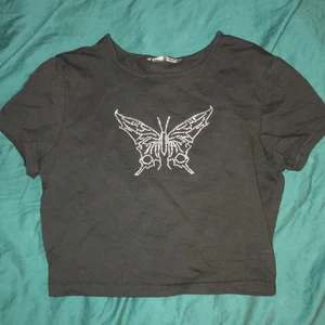 Svart croptop med fjäril  - Bara använd några gånger. Ganska liten i storleken men stretchig. 