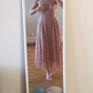 Spetsklänning med halterneck och vippig kjol. Pastellgammelrosa färg. Dragkedja i ryggen. Perfekt till bröllop o fest. Aldrig använd! 