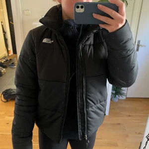 The North Face Vinterjacka - Säljer denna fina vinterjacka från märket The North Face. Den är kort, svart och puffig. Säljer den på grund av att den längre inte kommer till användning. Den är använd men är i mycket gott skick! Det är en storlek S. Det tillkommer en fraktkostnad om inte annat är överenskommet.