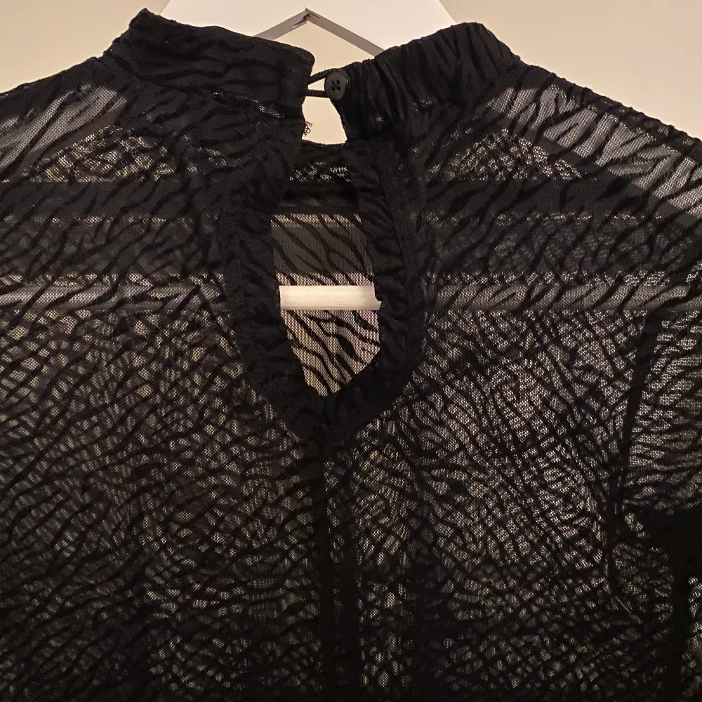 Detta är en svart tunn blus i storlek 158/164. Tröjan passar bra med ett linne under och har ett fint mönster av svart zebra mönster.. Blusar.