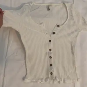 En enkel vit tröja med knappar, har en tajt passform som sitter fint. Använd några fåtal gånger, fortfarande som ny. Skickas nytvättad. Prisförslag 65kr eller bästa bud. 