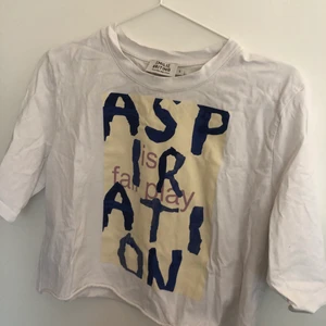 T-shirt - Vit t-shirt med tryck fram. Lite croppad men inte superkort. Använt ett fåtal gånger, bra skick! 