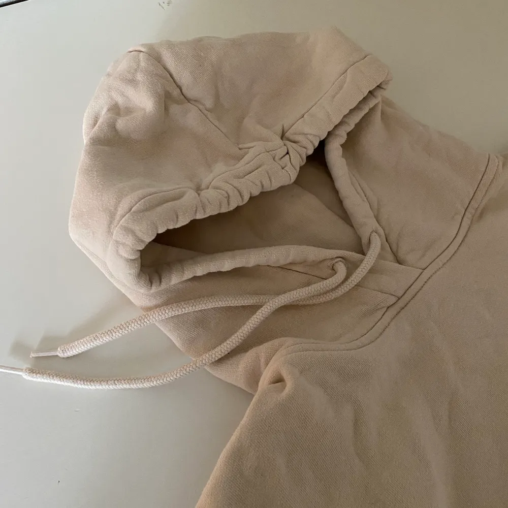 en beige hoodie som är oversized i modellen, strl XS men sitter som en L, köpare står för frakt. Hoodies.