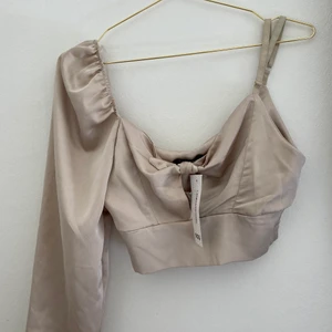 Beige satin topp - Skimrande beige topp som passar bra när man vill klä sig lite extra fint. Men den har tyvärr aldrig kommit till användning, och även prislappen är kvar!