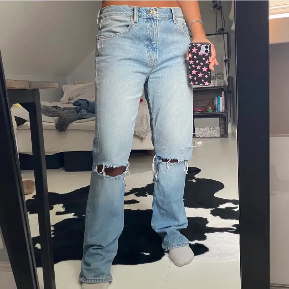 Säljer mina jeans från zara med hål på knäna. Sitter snyggt mid rise. Klippt bort lappen så ser ej storleken men de sitter snyggt på mig som är 36/38. . Jeans & Byxor.