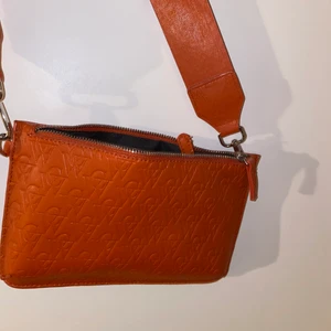 Carin Wester purse - En Carin Wester väska i färgen orange som använts en gång. Finns även en Carin Wester rem som man köper enskild i butik.