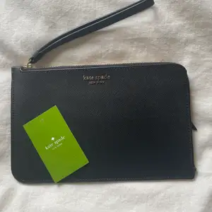 Oanvänd kate spade clutch, köpt i deras egna affär, givetvis äkta, certifikat och prislappar finns kvar, kortfack på insidan och ett fack på baksidan. Nypris: 1400 kr