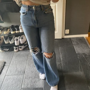Jeans från Gina Tricot - Vida blå jeans från Gina Tricot med hål på knäna. Väldigt snygga men har tyvärr blivit lite för små för mig. Storlek 36. Inte mycket använda.