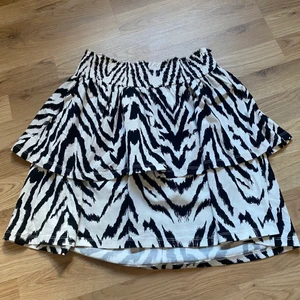 Kjol - Säljer en svart/vit kjol i storlek M ifrån gina tricot, använd endast en gång. 